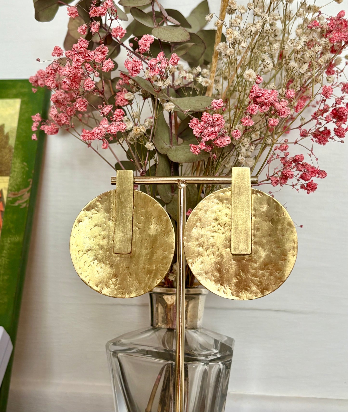 Pendientes dorados con forma de sol, simbolizan luz interior