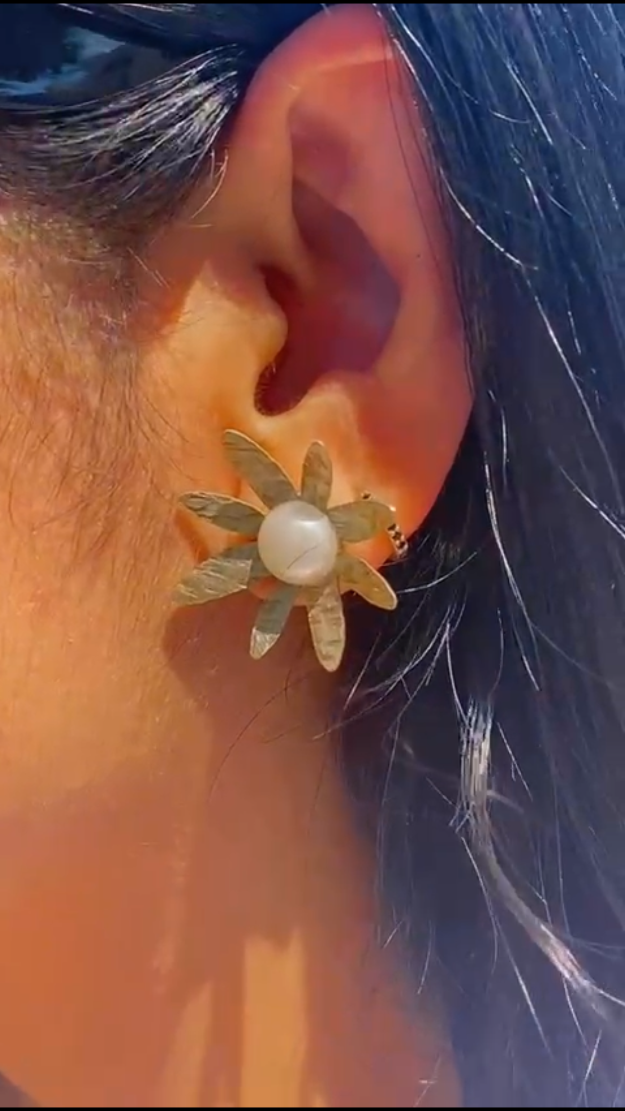 Oreja de mujer con pendientes en forma de Margaritas, hechos a mano en Latón. En nuestro taller artesanal del centro de Madrid. 