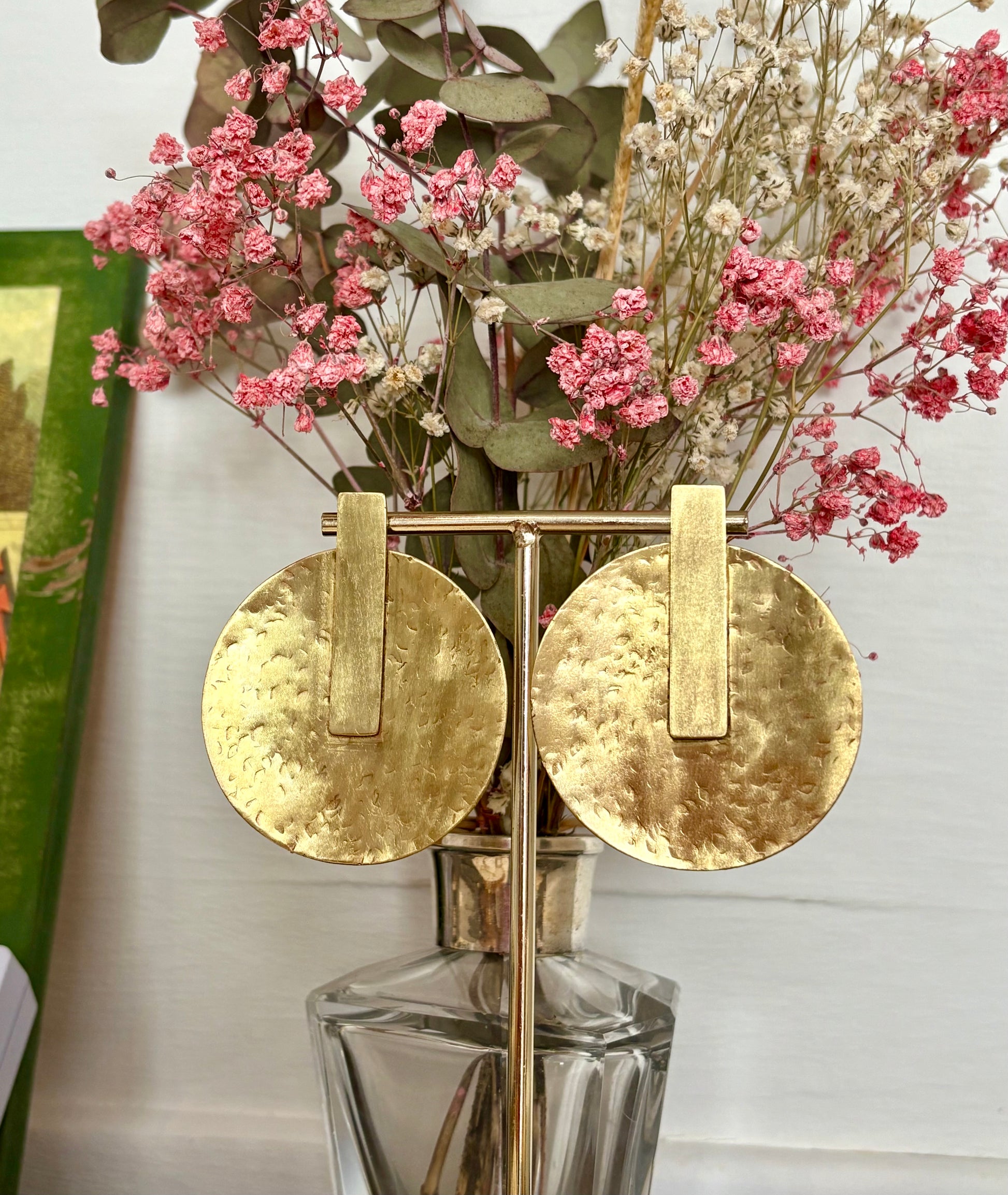 Pendientes dorados con forma de sol, simbolizan luz interior