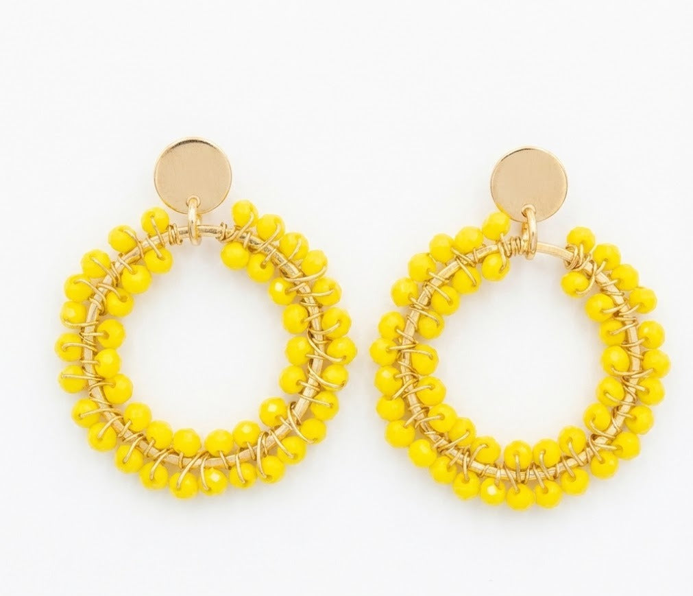 pendientes tejidos con hilo dorado y cristales amarillos en fondo blanco 